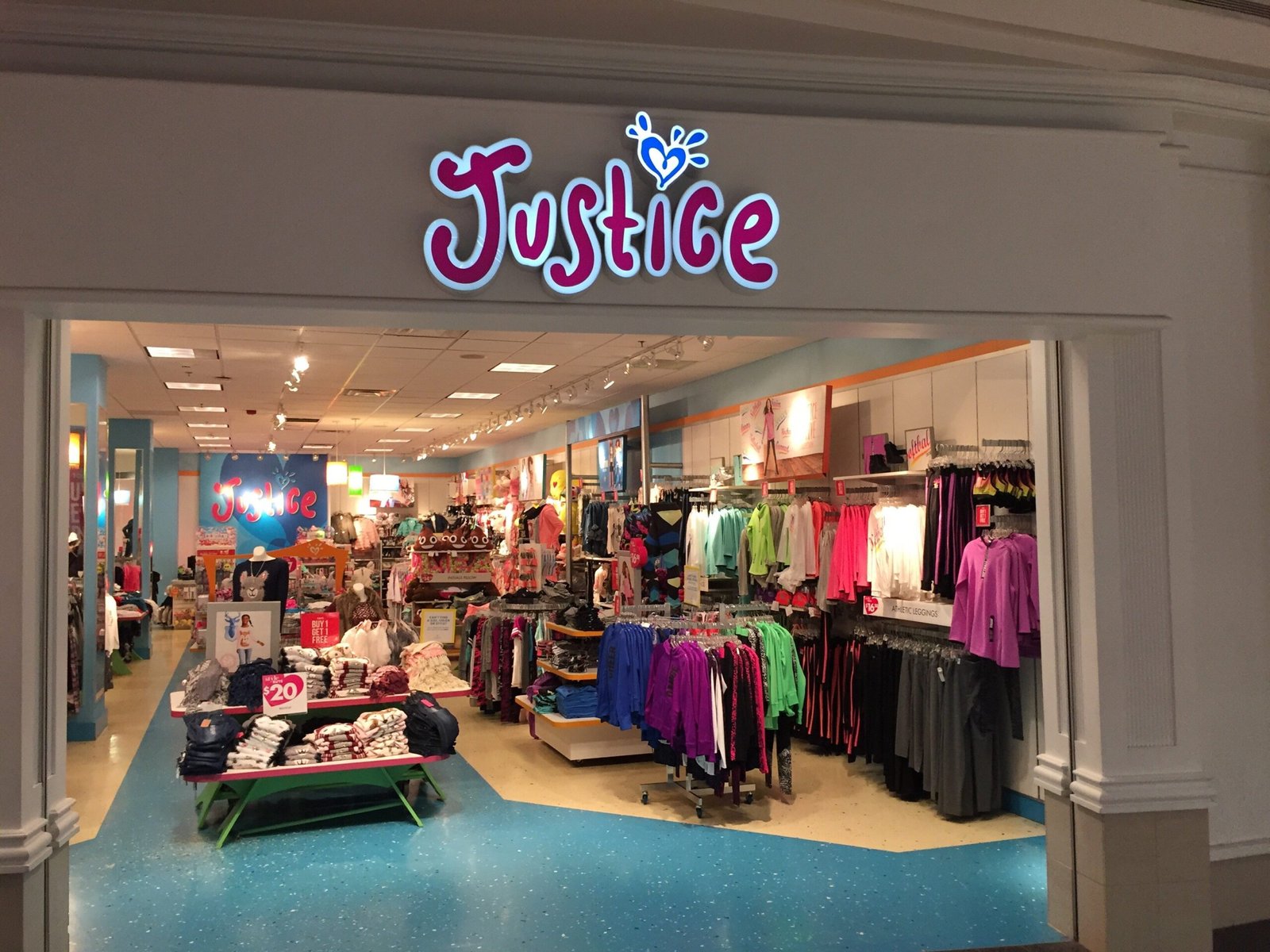 Justice clothing store display featuring colorful tween fashion, sparkly accessories, and vibrant brand atmosphere